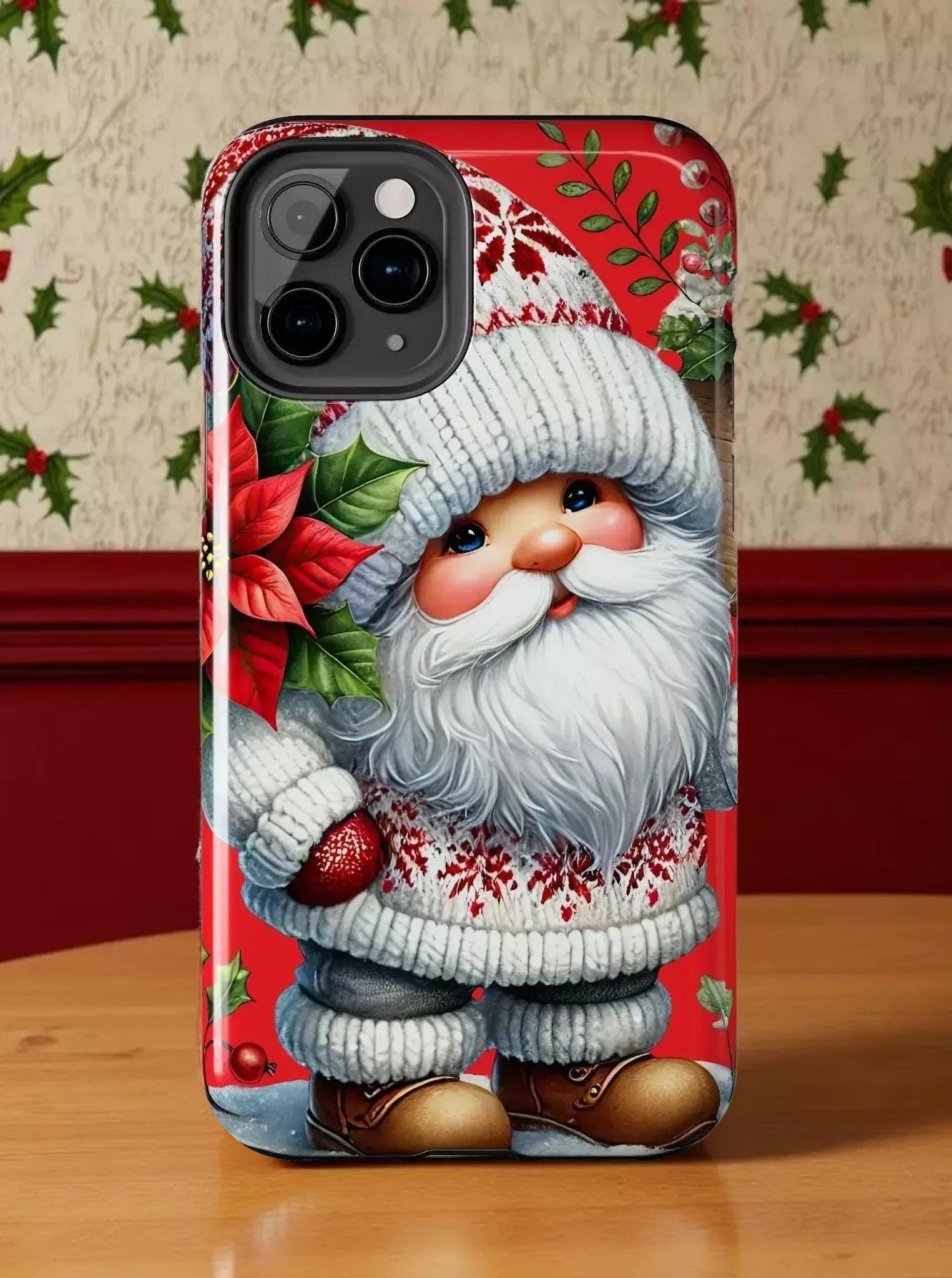 A phone case featuring a Christmas-themed design with a smiling Santa Claus figure wearing a white hat and sweater, holding a poinsettia plant.