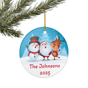 A Christmas ornament featuring Santa Claus, a reindeer, and a snowman, all dressed in winter attire, against a snowy background.