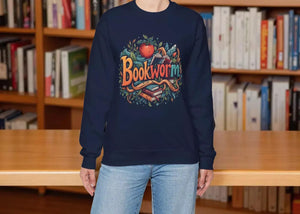 A woman wearing a navy blue sweatshirt with a colorful graphic design featuring the text "Bookworm" surrounded by various book-related elements.