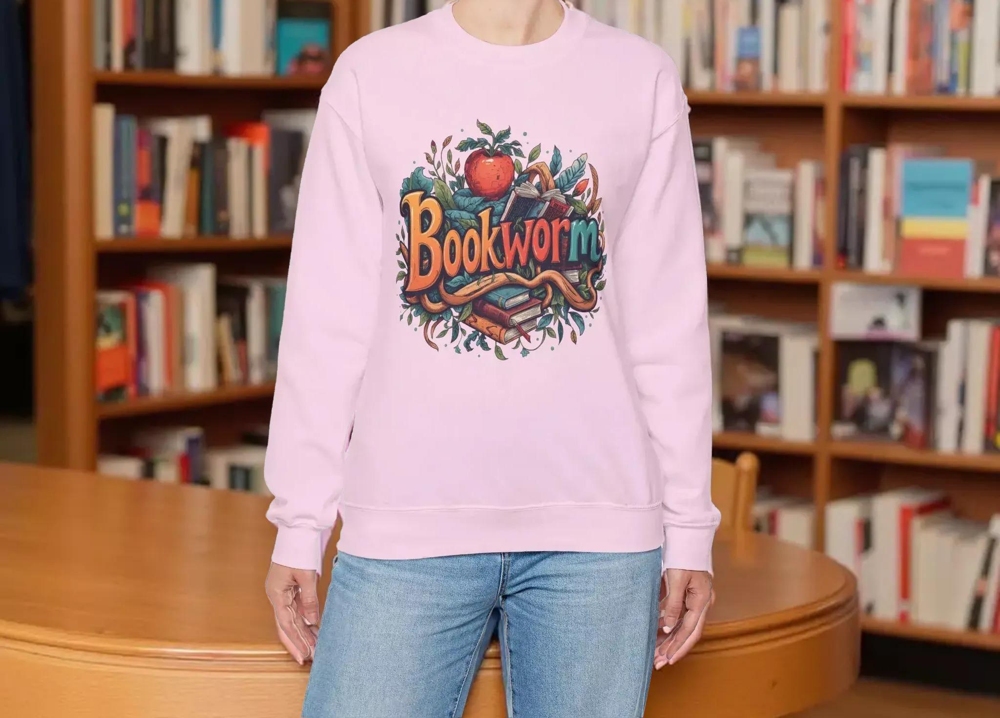 A woman wearing a pink sweatshirt with a colorful graphic design featuring the text "Book Worm" and an illustration of a book and a worm.