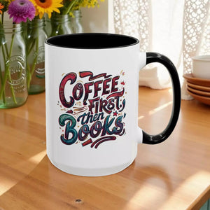 A white mug with a black handle, featuring a colorful and stylized text design that reads "Coffee first then books".