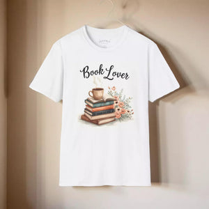 A white t-shirt with a graphic design depicting a stack of books with a cup of coffee and flowers on top.