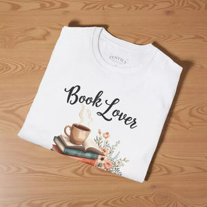 A white t-shirt with a printed design that includes a cup of coffee, a stack of books, and flowers. The text on the t-shirt says "Book Lover".