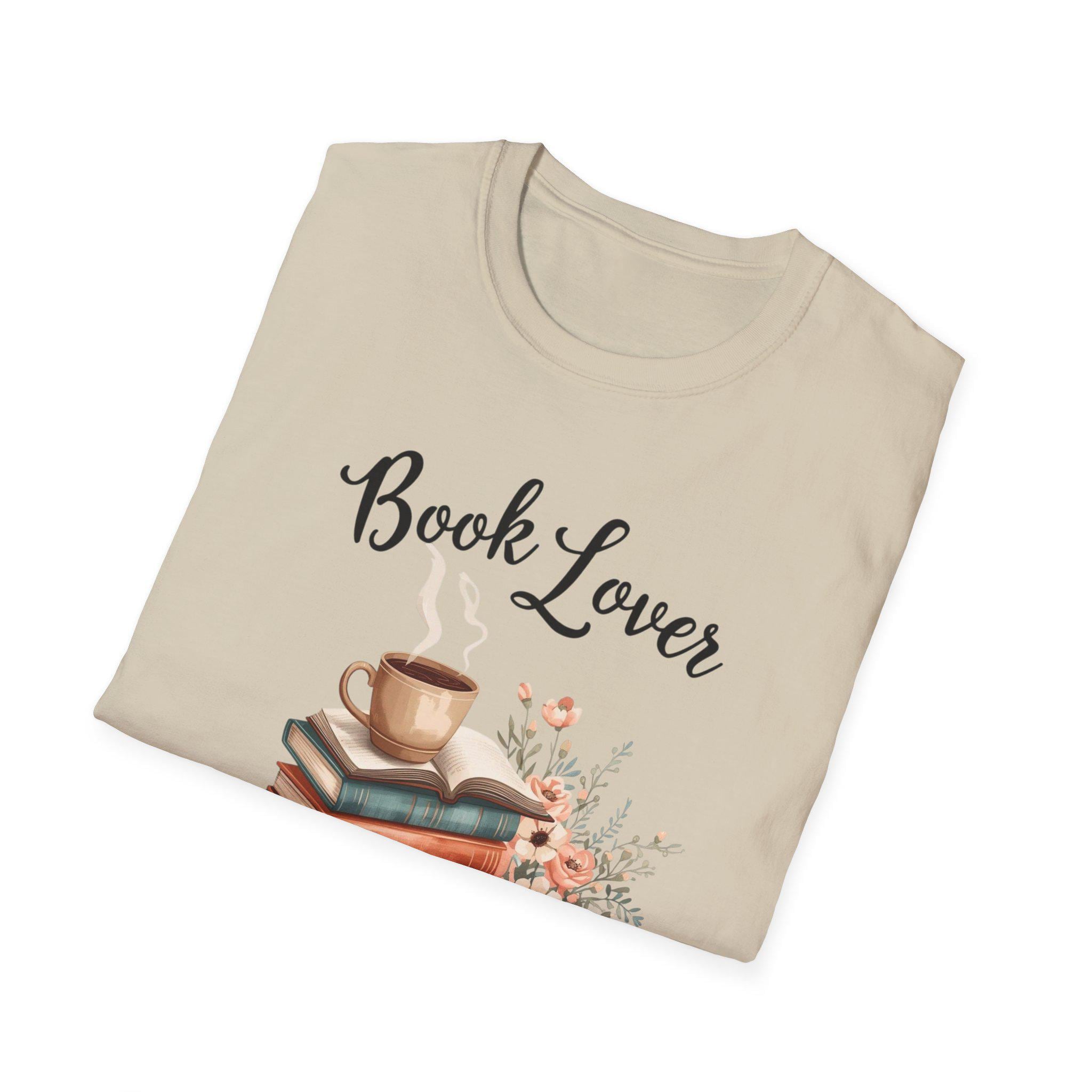 A beige t-shirt with a printed design that includes a cup of coffee, a stack of books, and flowers. The text on the t-shirt says "Book Lover".