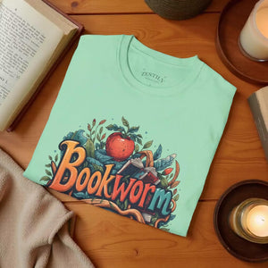 A green t-shirt with a colorful graphic design featuring the text "Book Worm" surrounded by various elements such as leaves, flowers, and an apple.