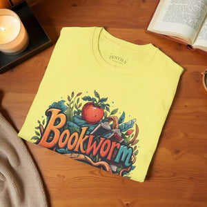 A yellow t-shirt with a colorful graphic design featuring the text "Book Worm" surrounded by various elements such as leaves, an apple, and a book.