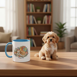 A white mug with a blue rim, featuring a cartoon illustration of a dog lying on a book surrounded by flowers and leaves.