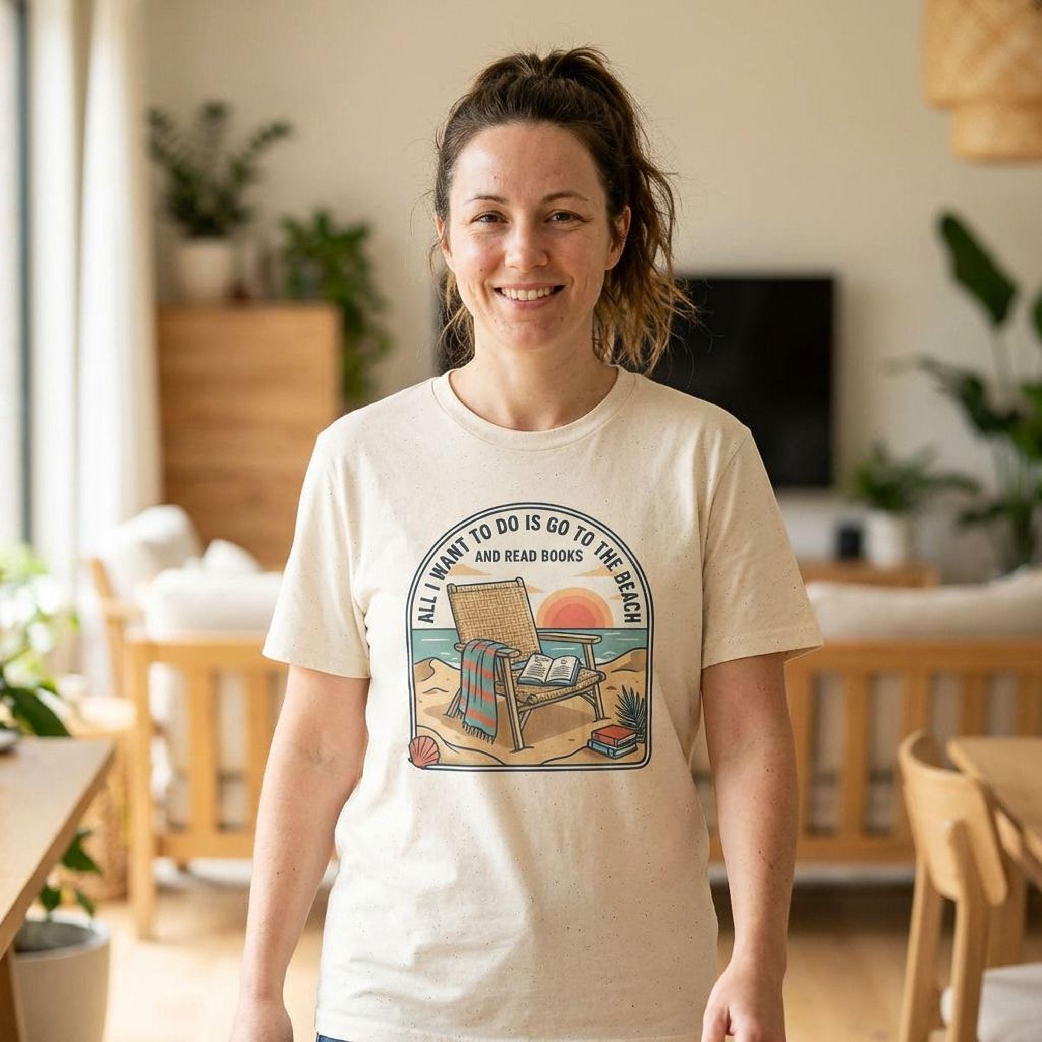 A woman wearing a white t-shirt with a graphic design of a beach scene and the text "All I want to do is go to the beach and read books" is smiling in a room with a television and potted plants.