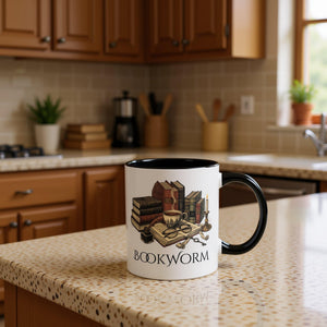 A white mug with a black handle, featuring an illustration of a bookworm surrounded by various books, a cup of coffee, and other objects associated with reading and writing.