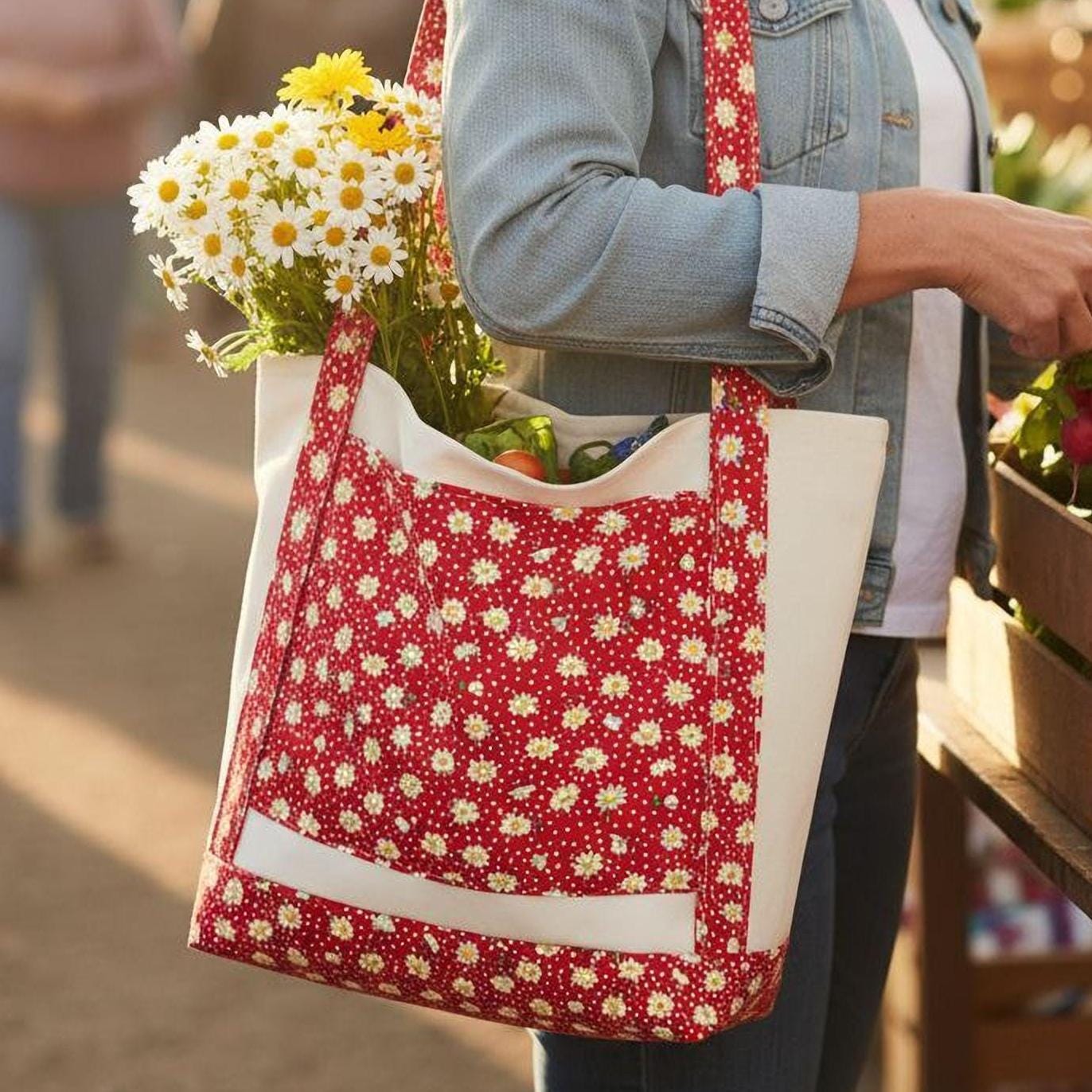 A woman is shopping at an outdoor market, examining vegetables and flowers in a basket. She is carrying a red and white polka dot tote bag.
