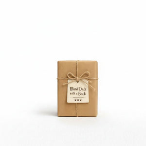 A small brown gift box with a tag that reads "Blind Date with a Book" and a bow tied around it.