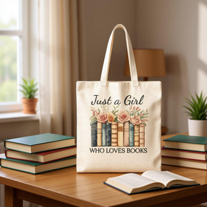 A beige tote bag with a printed design of a row of books and the text "Just a Girl Who Loves Books" printed on it.