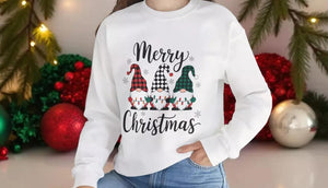 A woman wearing a white sweatshirt with a Christmas-themed design and text, smiling at the camera.