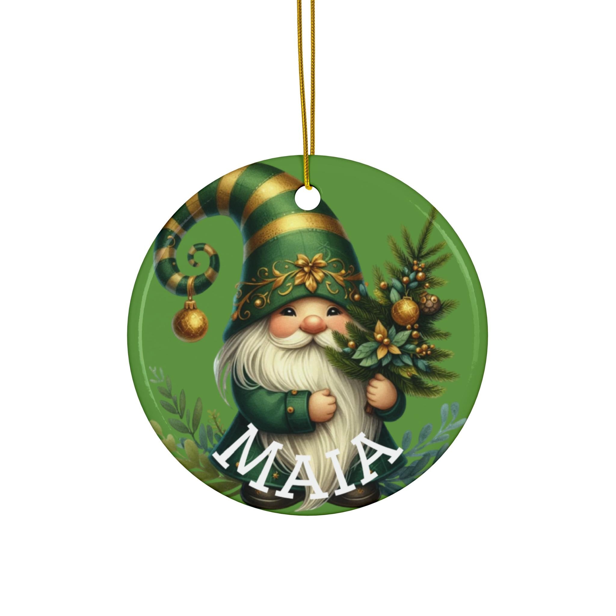 A round ornament featuring a gnome holding a Christmas tree and a gold bell.