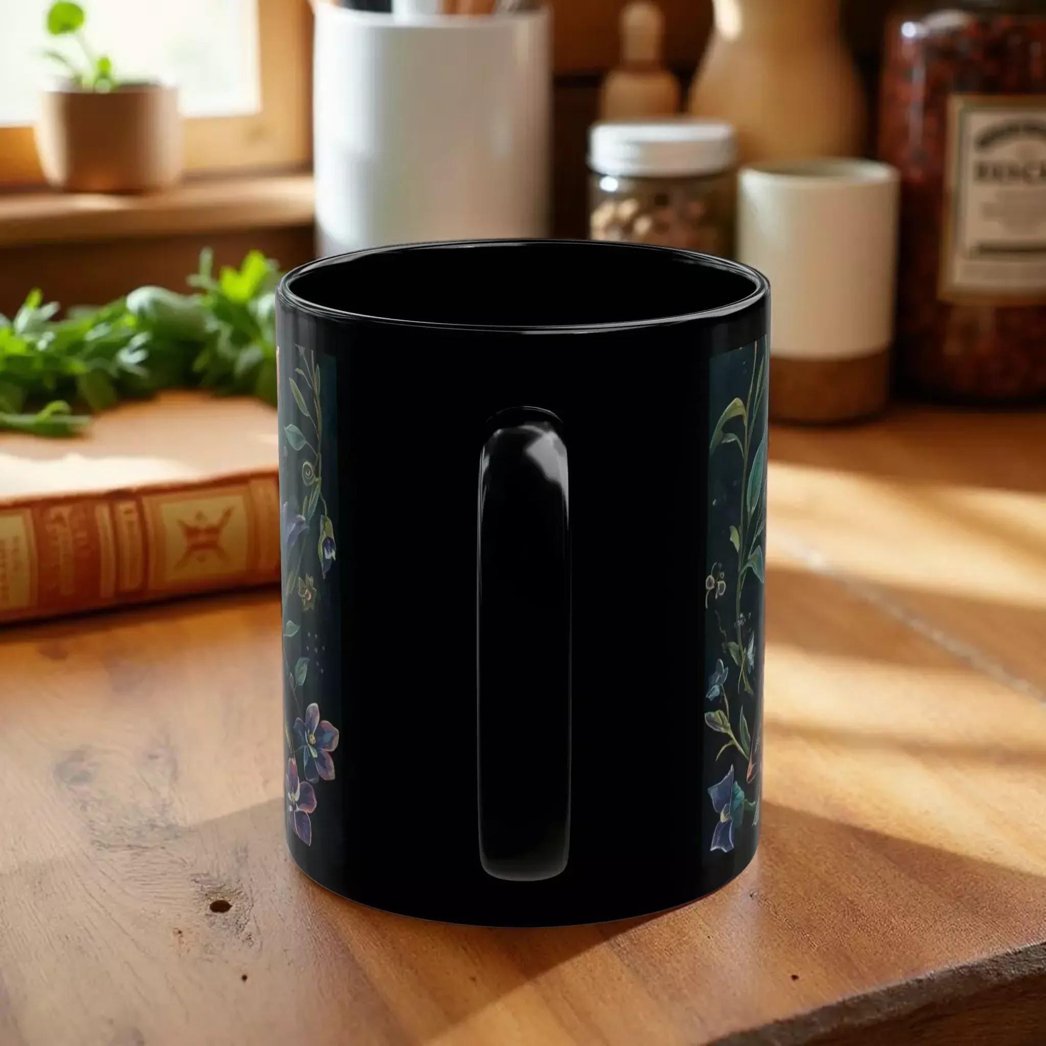 A black mug with a floral design on the side.