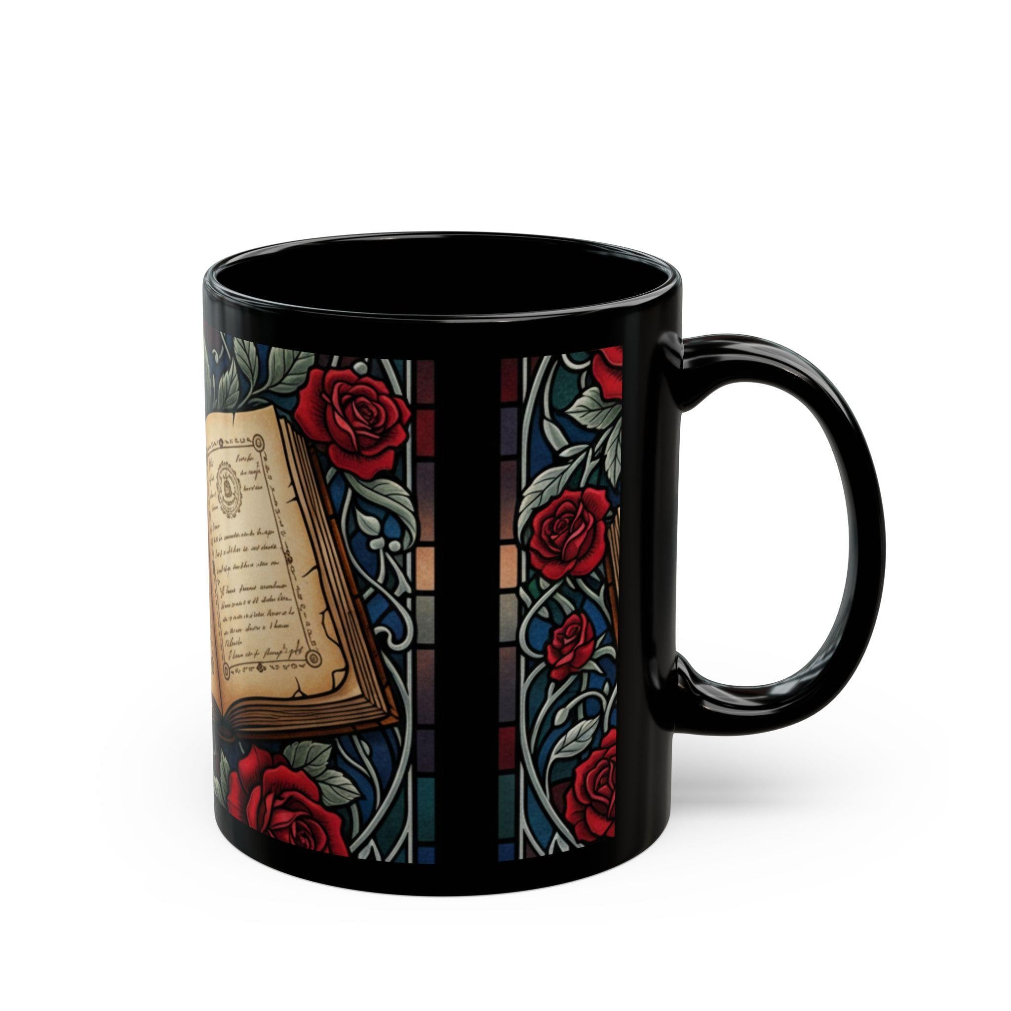 A black coffee mug with a stained glass design featuring a book and red roses.