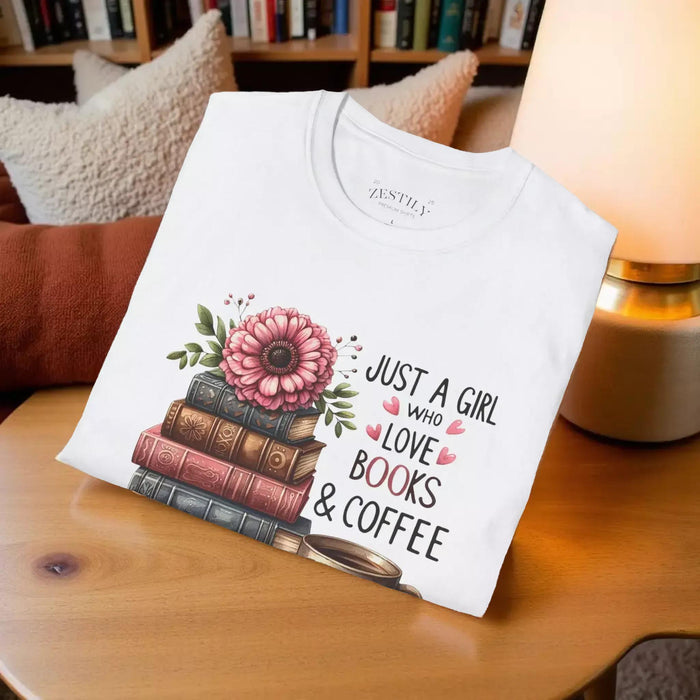 A smiling woman wearing a t-shirt with a graphic design of stacked books and coffee cups.