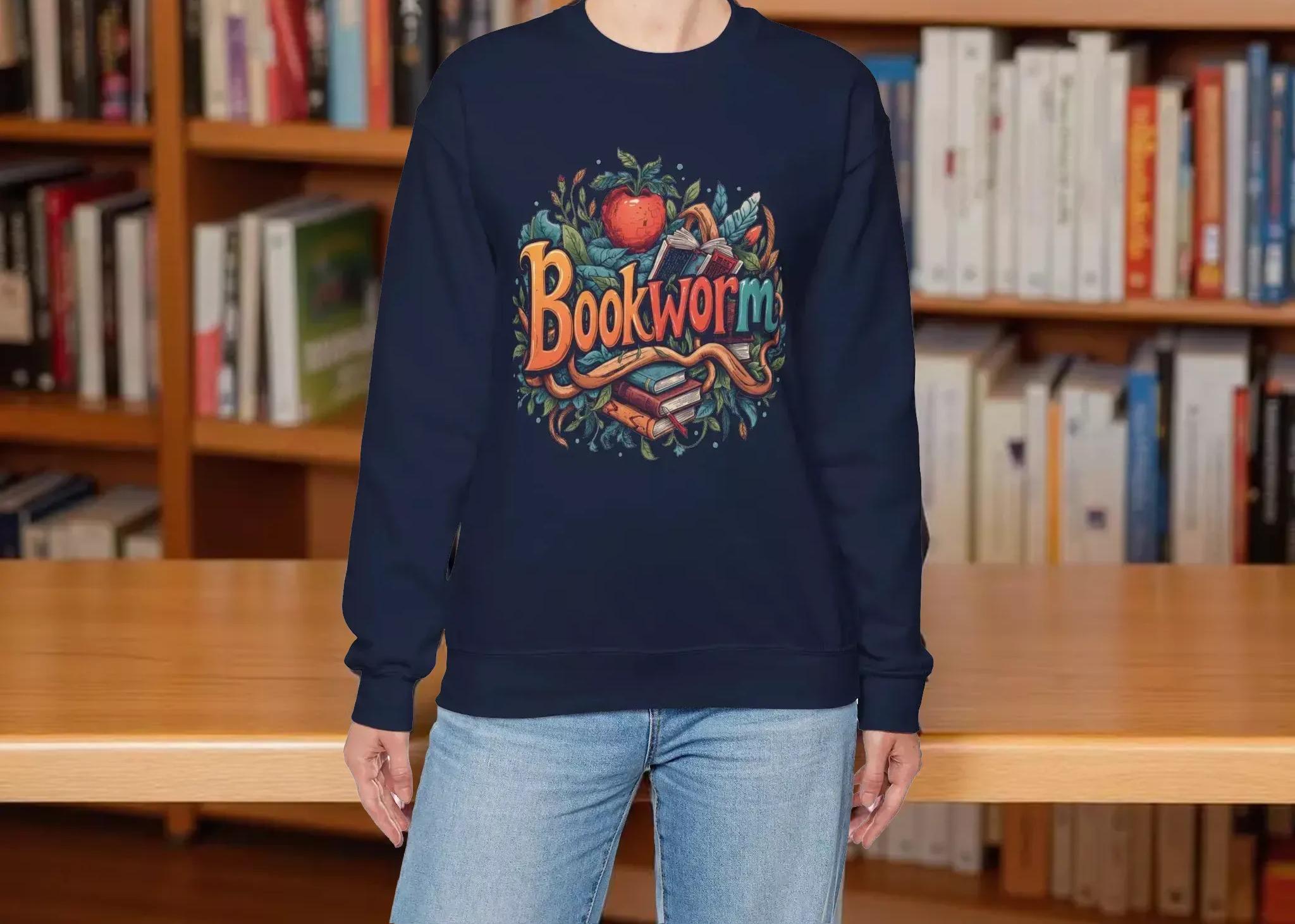 A woman wearing a navy blue sweatshirt with a colorful graphic design featuring the text "Bookworm" surrounded by various book-related elements.