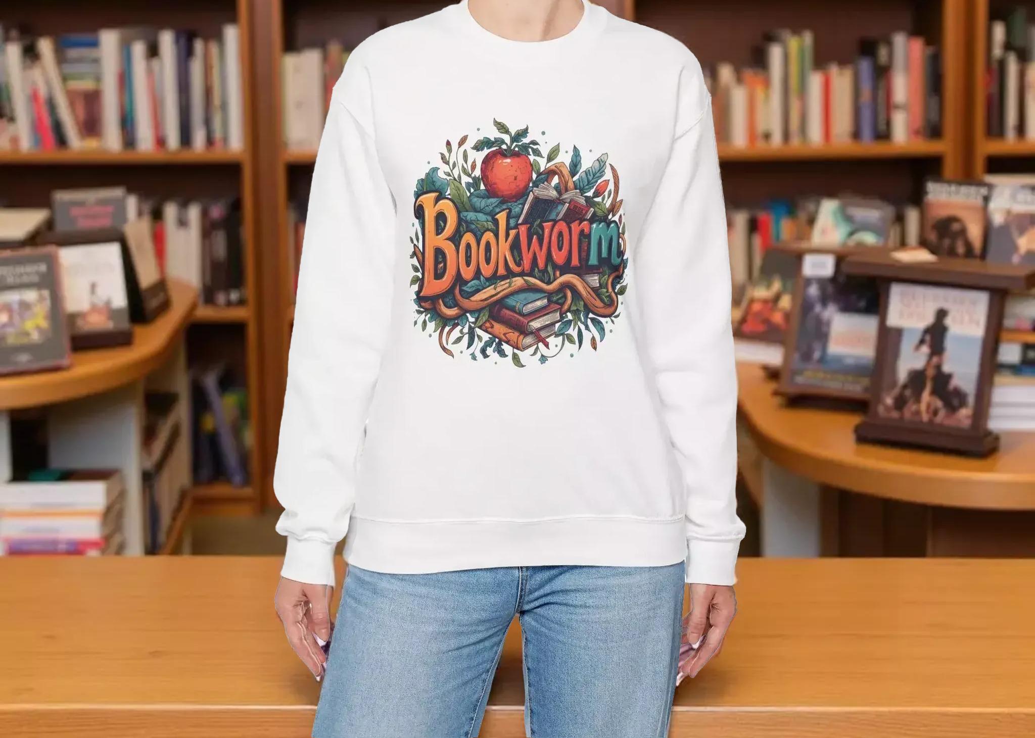 A woman wearing a white sweatshirt with a colorful graphic design featuring the text "Book Worm" and an illustration of a book and a worm.
