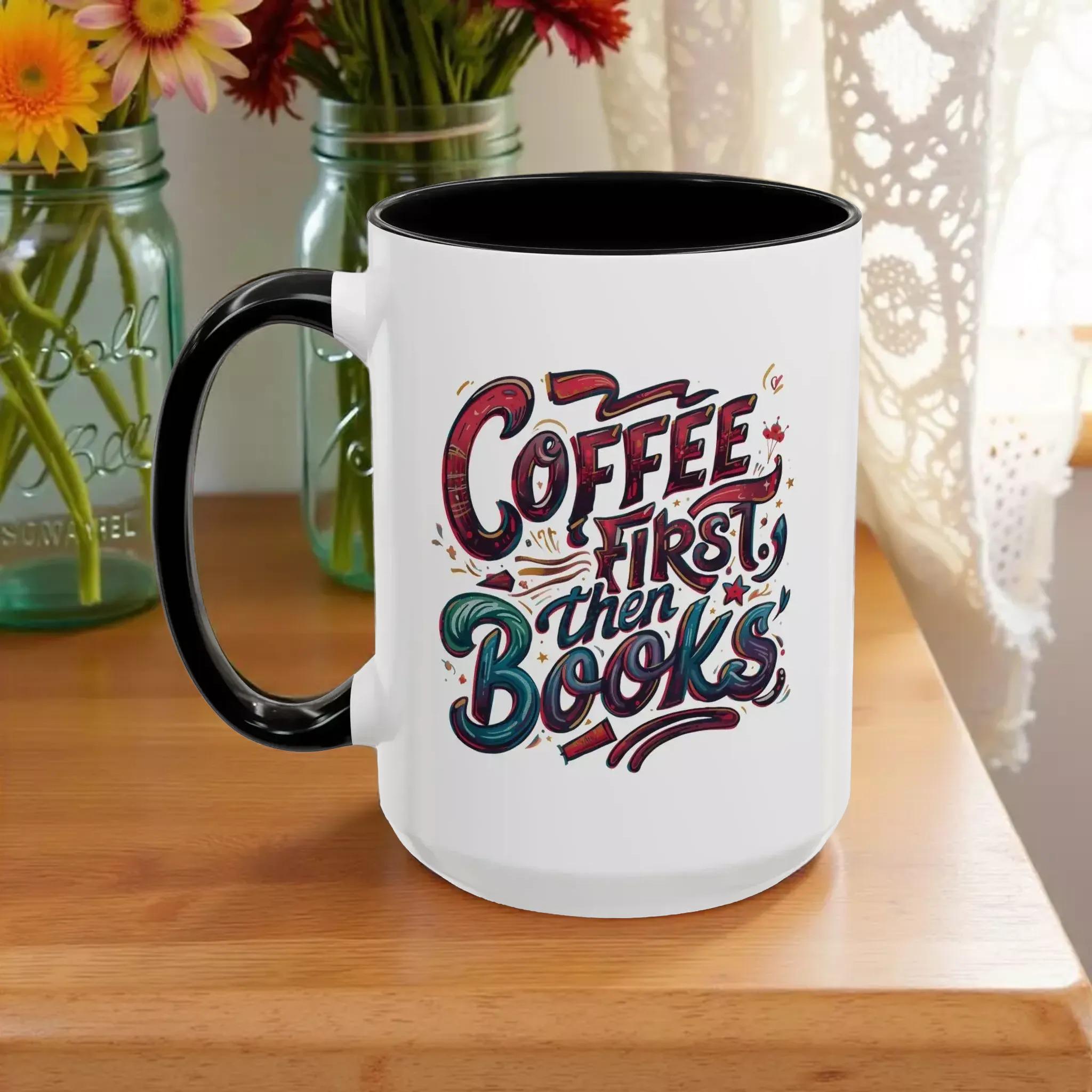 A white mug with a black handle, featuring a colorful and stylized text design that reads "Coffee first then books".