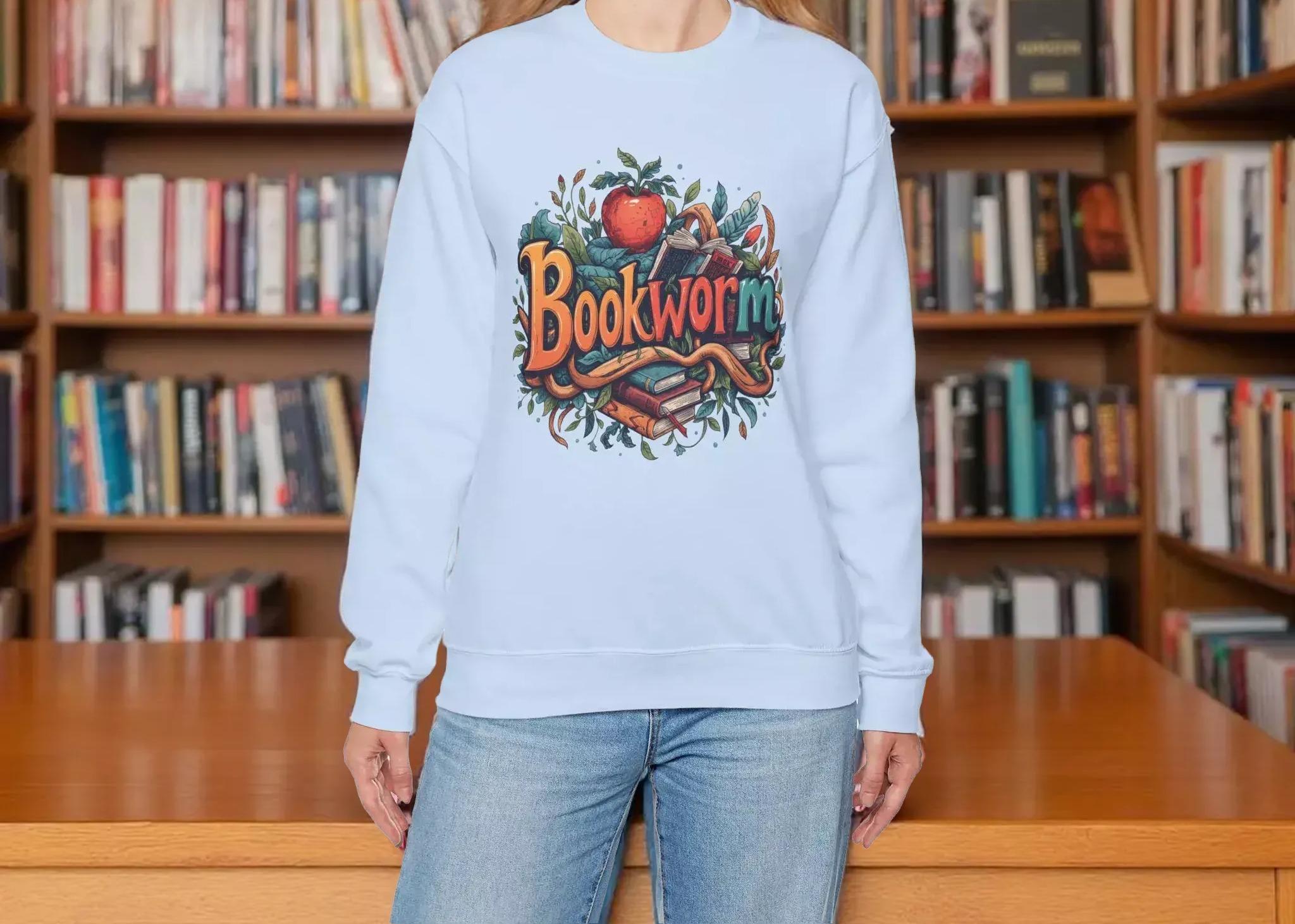 A woman wearing a light blue sweatshirt with a colorful graphic design featuring the text "Bookworm" and an illustration of a book and a worm.