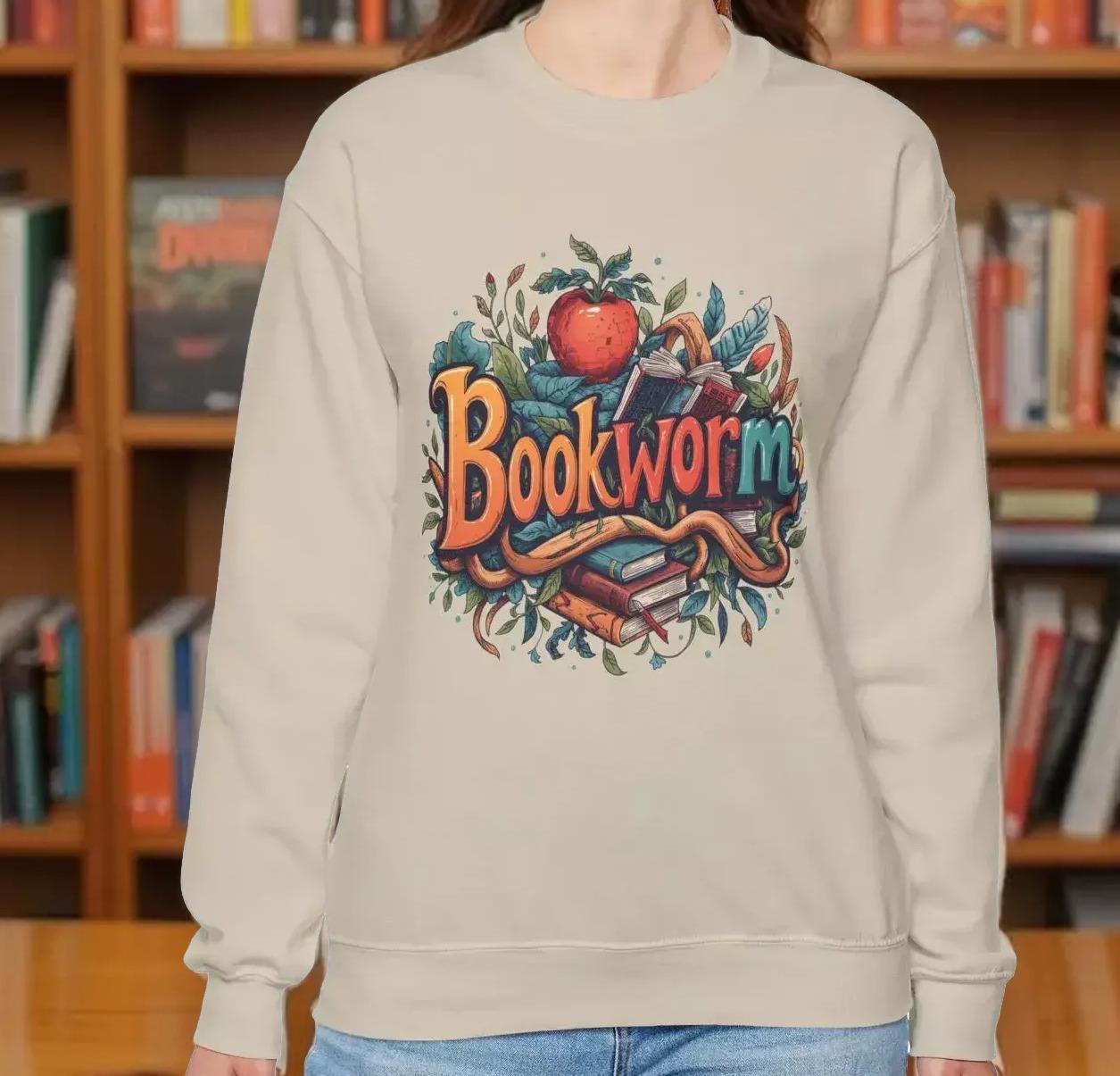 A woman wearing a beige sweater with a colorful graphic design featuring the text "Book Worm" and an illustration of a book and a worm.