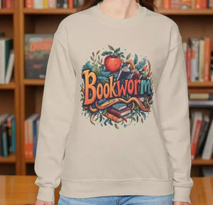 A woman wearing a beige sweater with a colorful graphic design featuring the text "Book Worm" and an illustration of a book and a worm.