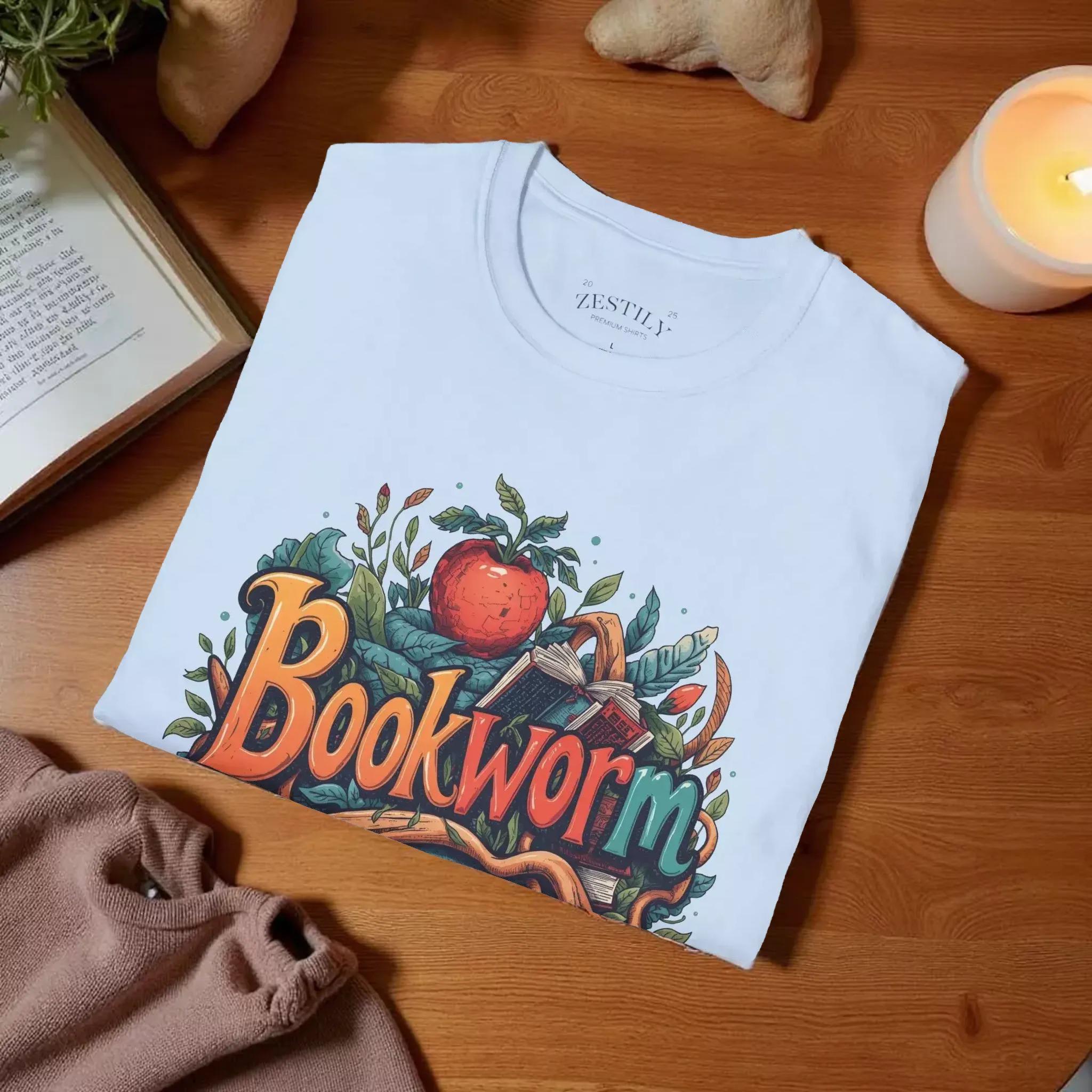A light blue t-shirt with a colorful graphic design featuring the text "Bookworm" surrounded by various elements such as leaves, an apple, and a book.