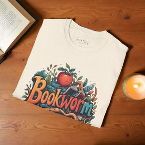The image is a white t-shirt with a colorful graphic design featuring the word "Bookworm" surrounded by various elements such as leaves, an apple, and a book.