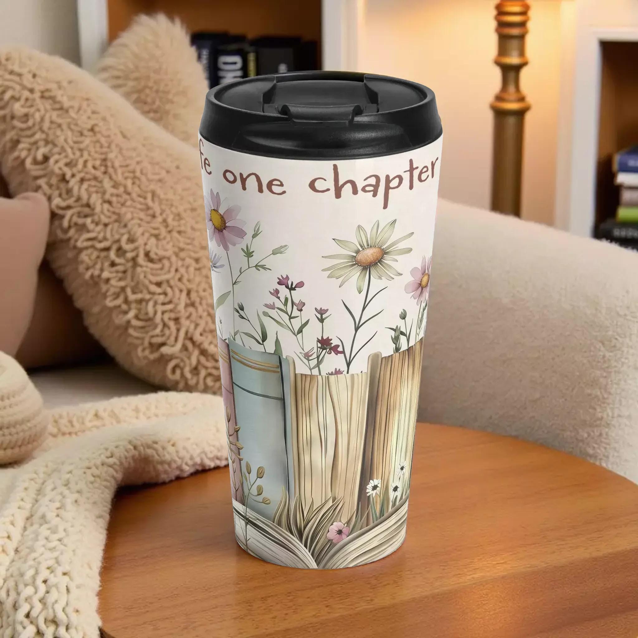 A travel mug with a floral design and the text "One chapter" printed on it.