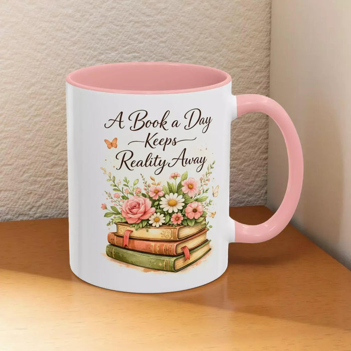 A white mug with a black handle, featuring a design of a stack of books with flowers on top.