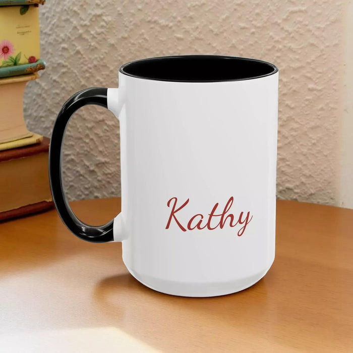 A white mug with a black handle, featuring a design of a stack of books with flowers on top.