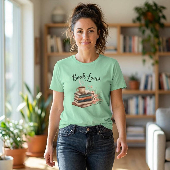 A beige t-shirt with a printed design that includes a cup of coffee, a stack of books, and flowers. The text on the t-shirt says "Book Lover".