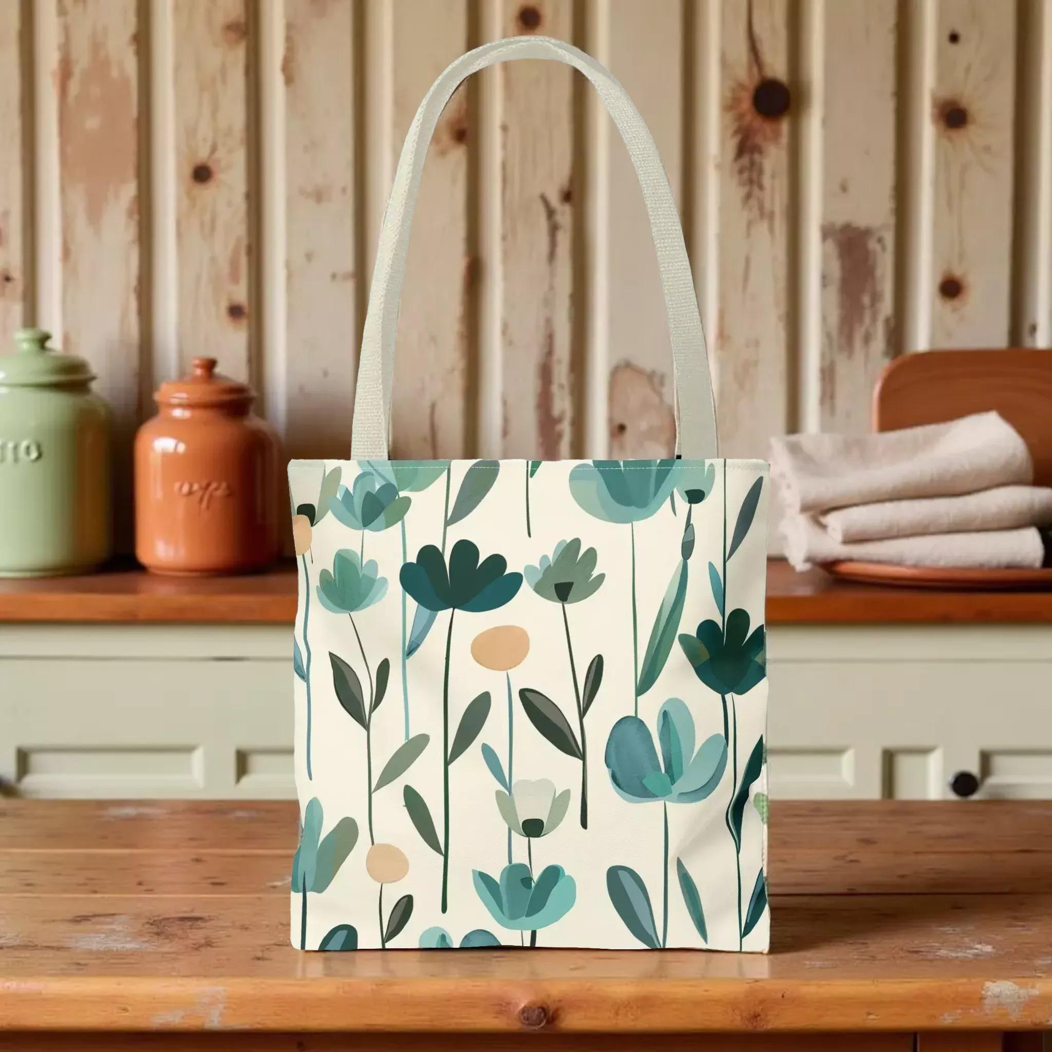 A white tote bag with a floral pattern printed on it, placed on a wooden surface.