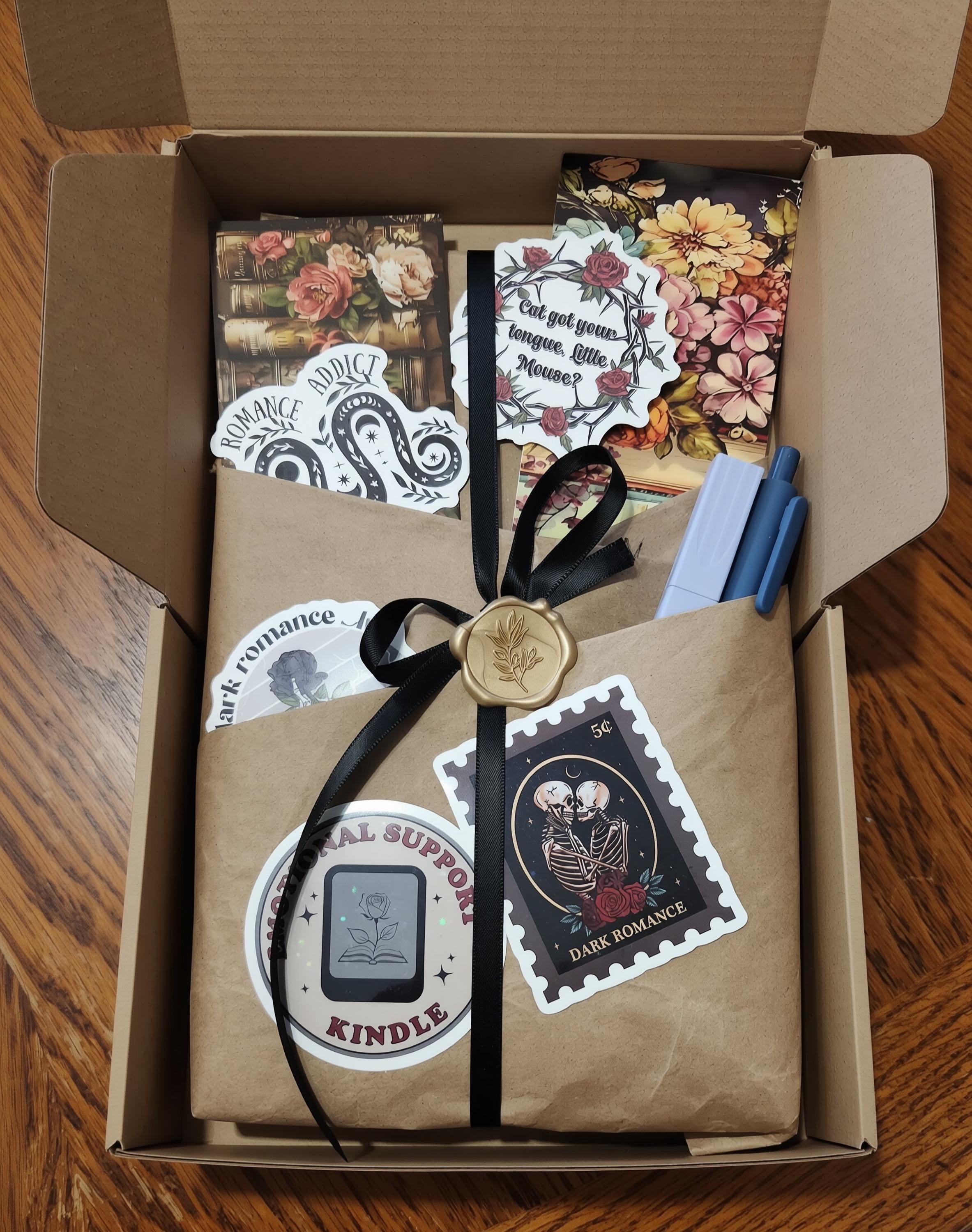 a cardboard box containing various items, including a book, a stamp, and some other decorative elements.