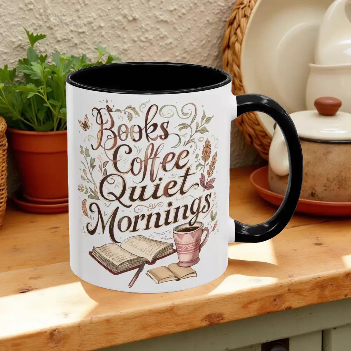A white mug with a black handle, featuring a printed design that says "Books Coffee Quiet Mornings" along with illustrations of an open book, a cup of coffee, and a warm beverage.