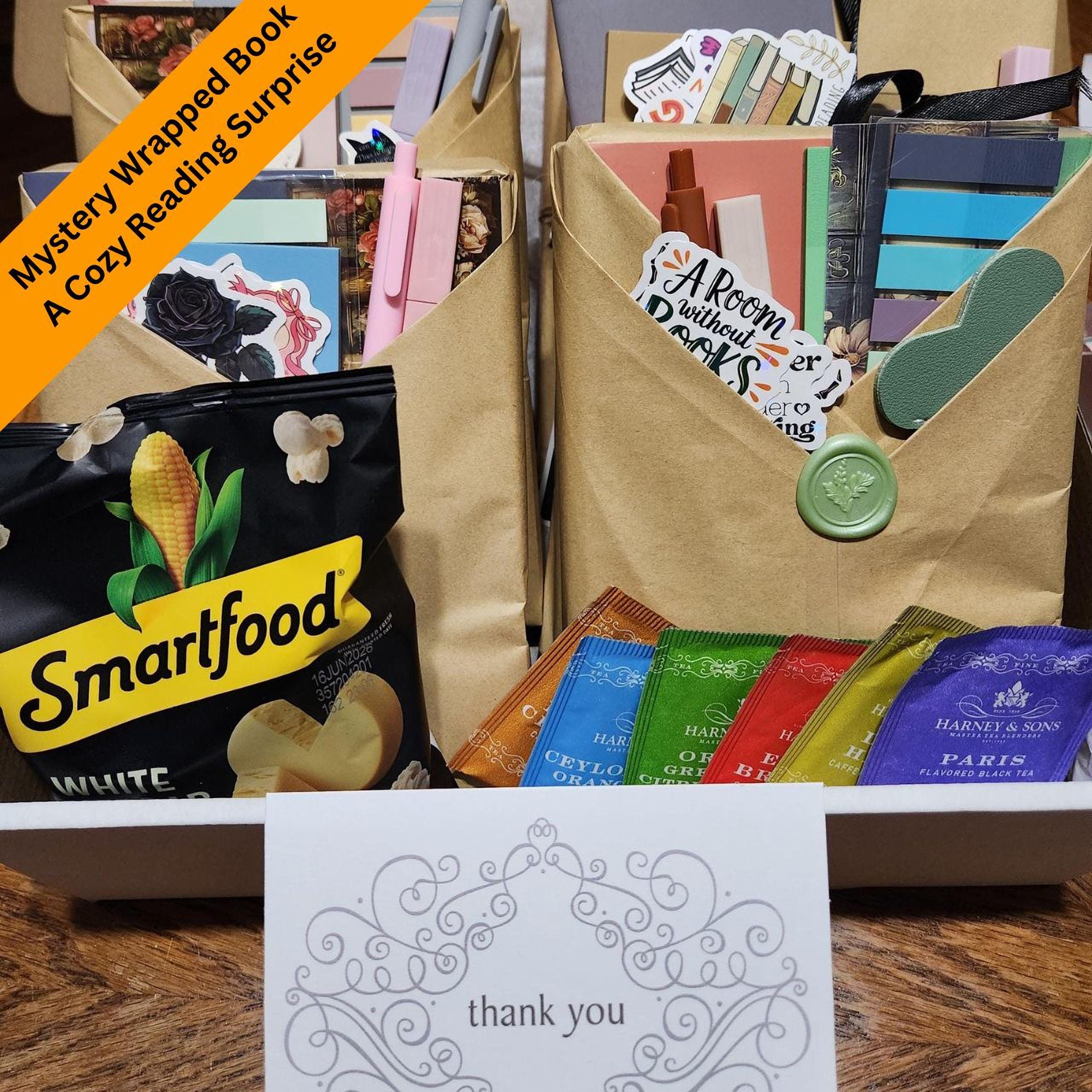 a collection of items, including a bag of chips, a book, and a note, arranged on a table.