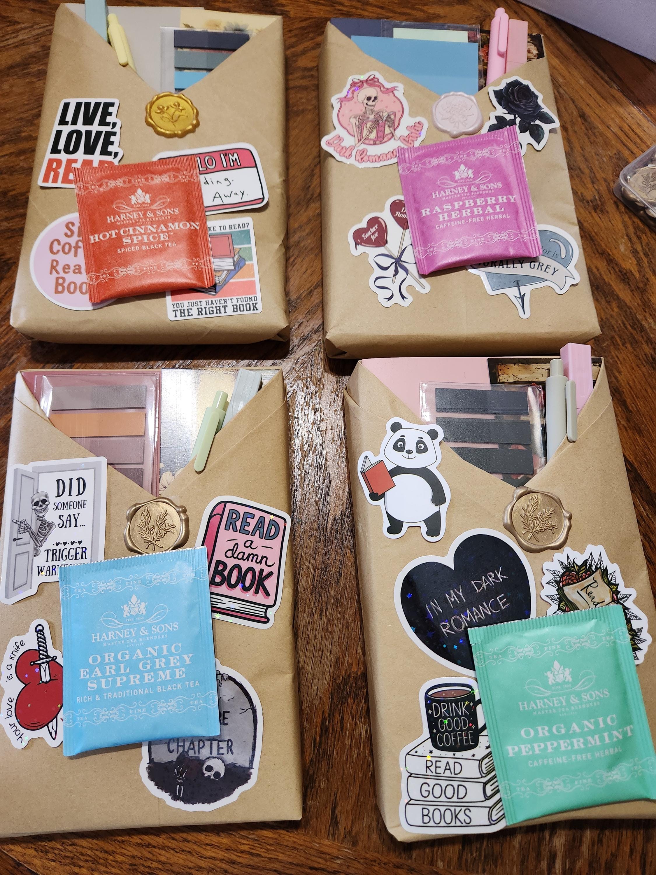 three wrapped packages with various stickers and labels on them, placed on a wooden surface.
