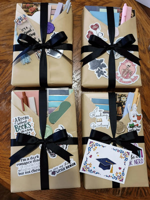 four wrapped books with black ribbons, each containing various stickers and decorations.