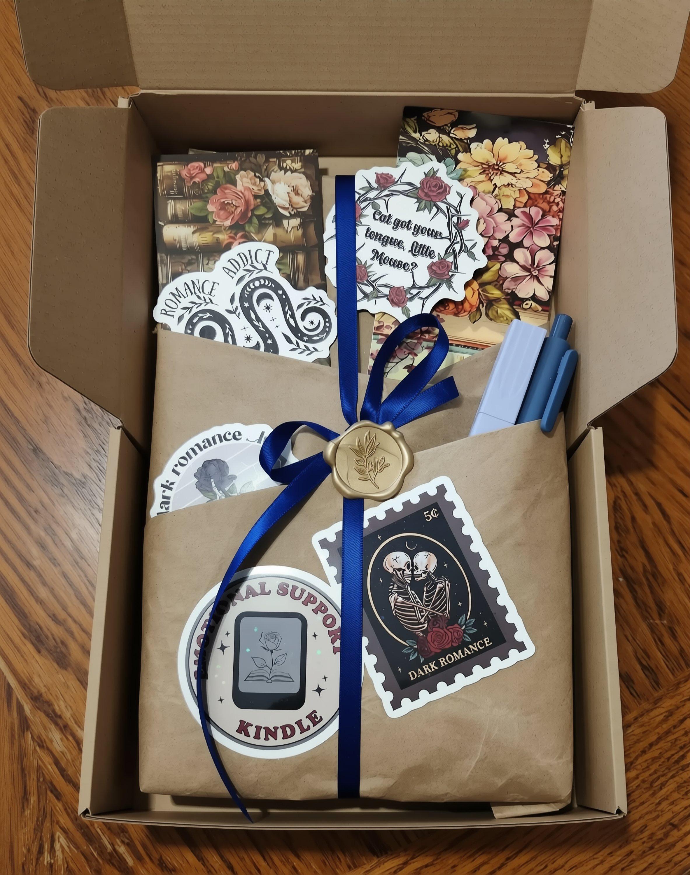 a cardboard box containing various items, including a book, a stamp, and some other decorative elements.