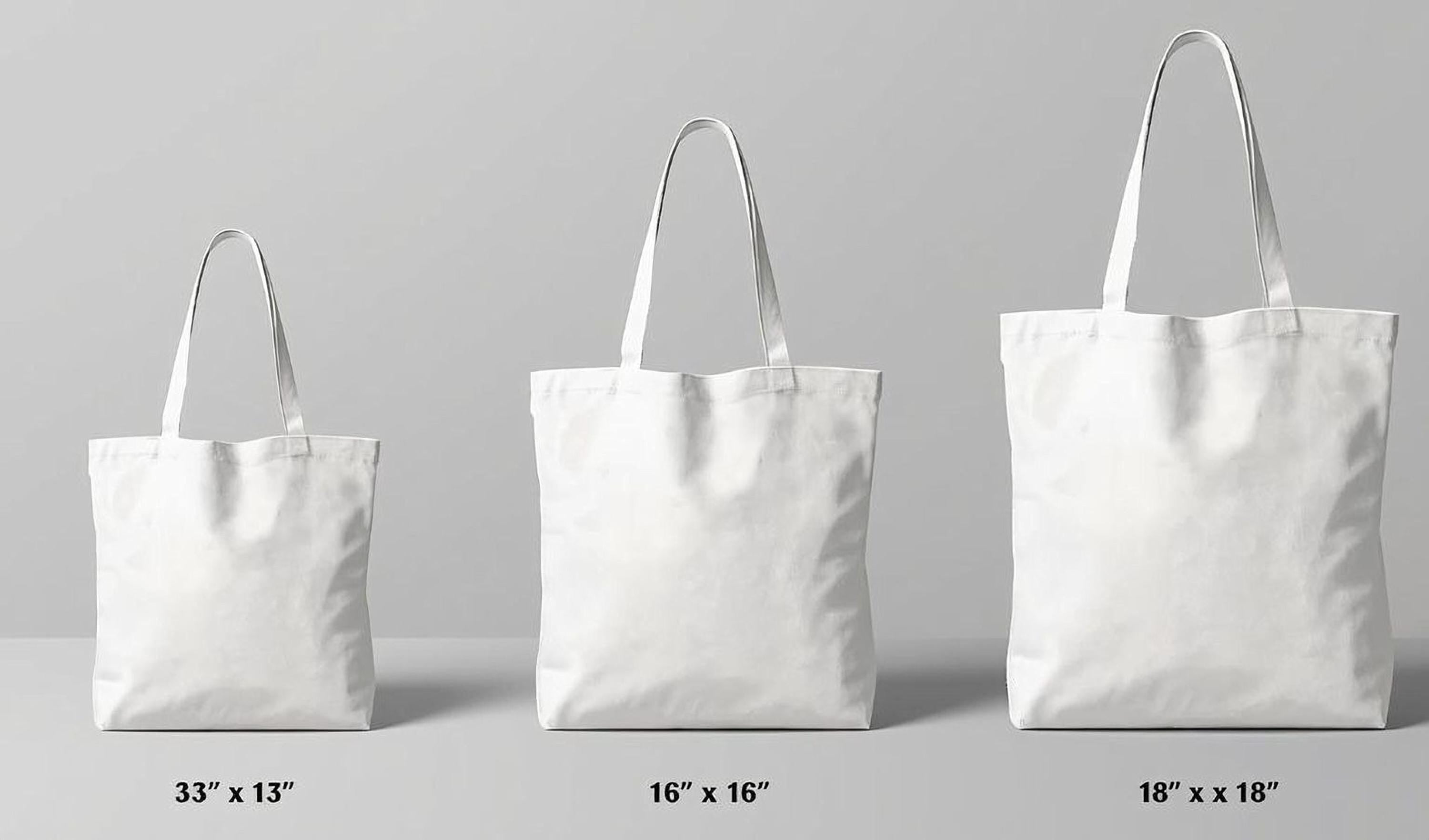 three white tote bags of different sizes, ranging from 33" to 18" in width.