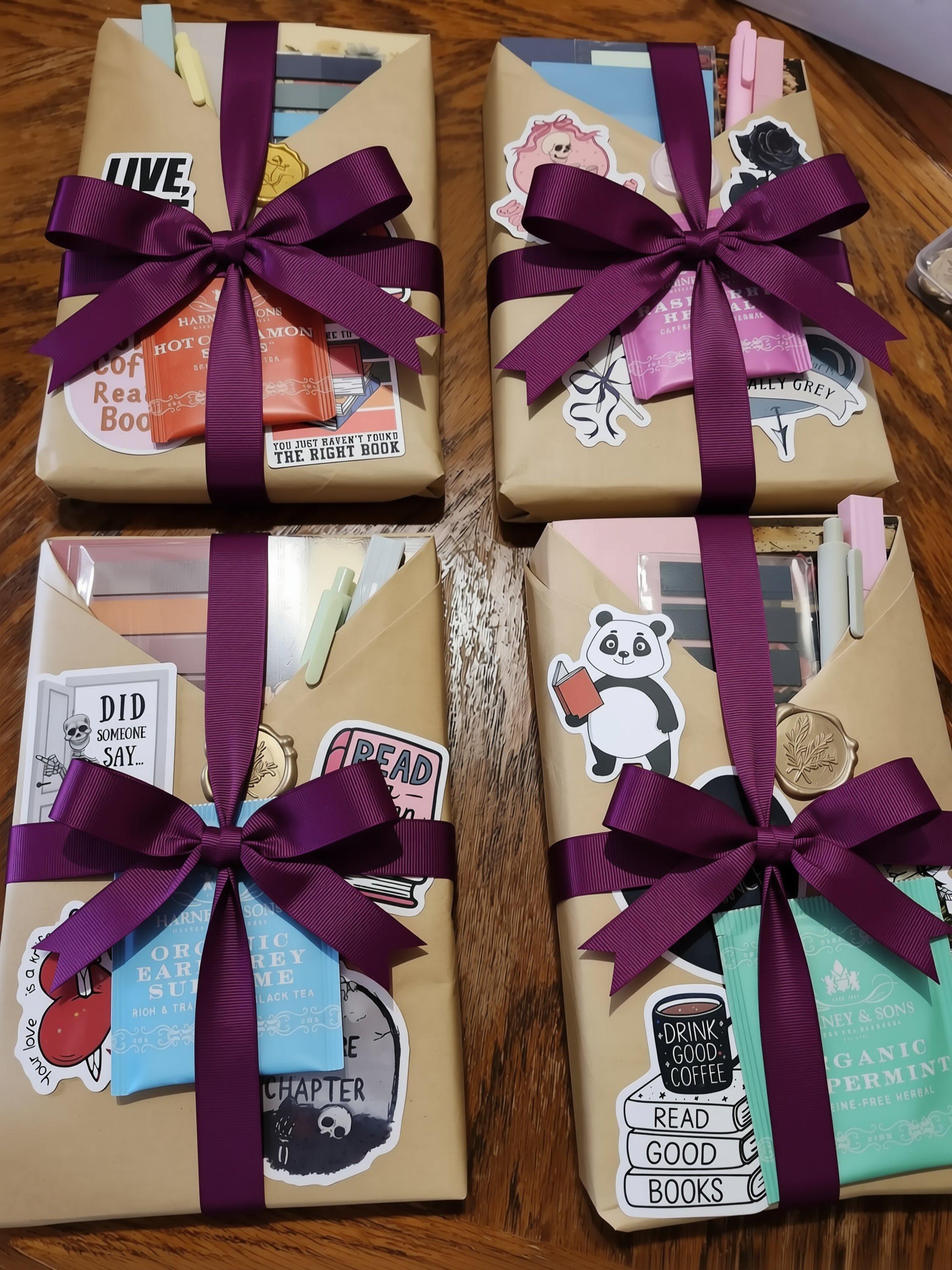 three wrapped packages with various stickers and labels, including a pink and black sticker, a green and black sticker, and a blue and white sticker.