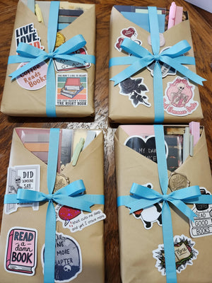 several wrapped books with various stickers and decorations on them, placed on a wooden surface.