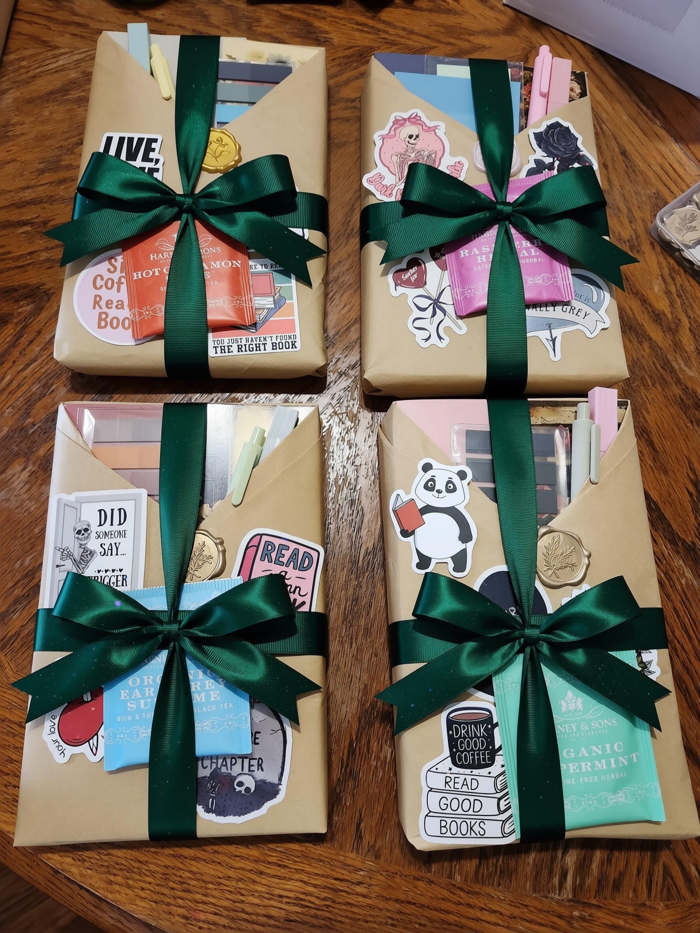 three wrapped packages on a wooden surface, each adorned with various stickers and decorative elements.