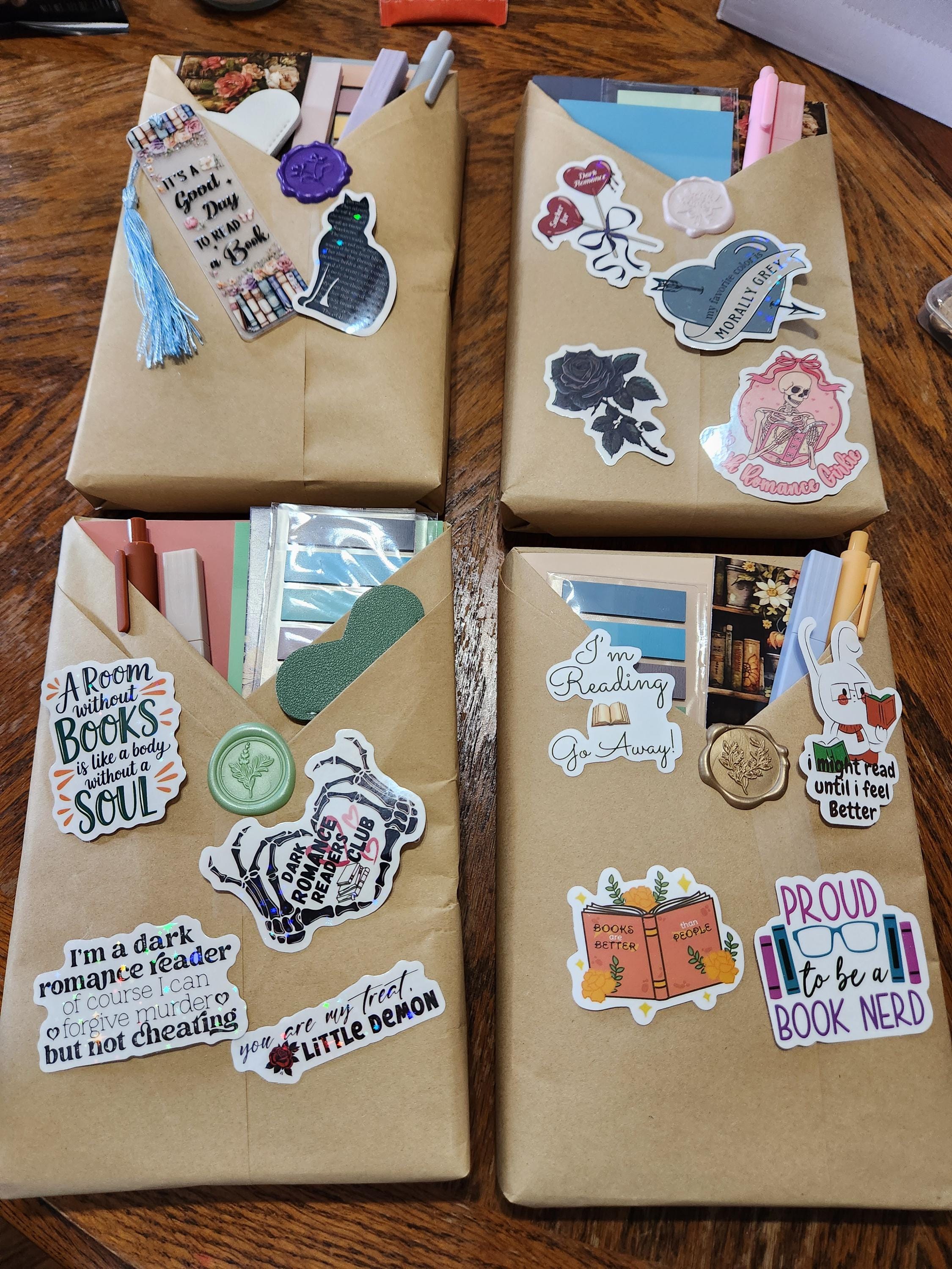 two brown envelopes with various stickers and decorations attached to them, placed on a wooden surface.