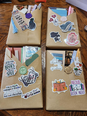 two brown envelopes with various stickers and decorations attached to them, placed on a wooden surface.