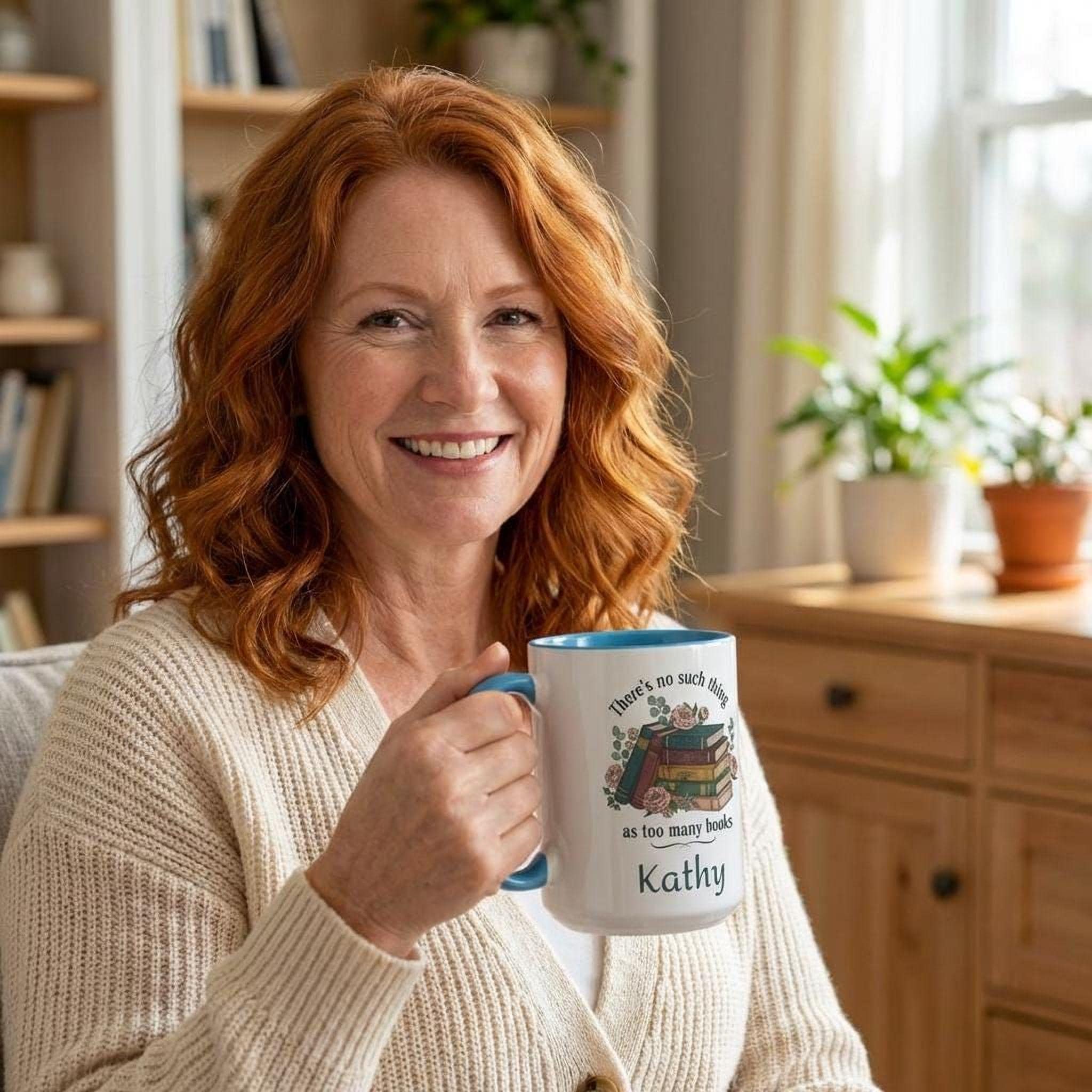 A smiling woman with red hair holding a mug with a book design.