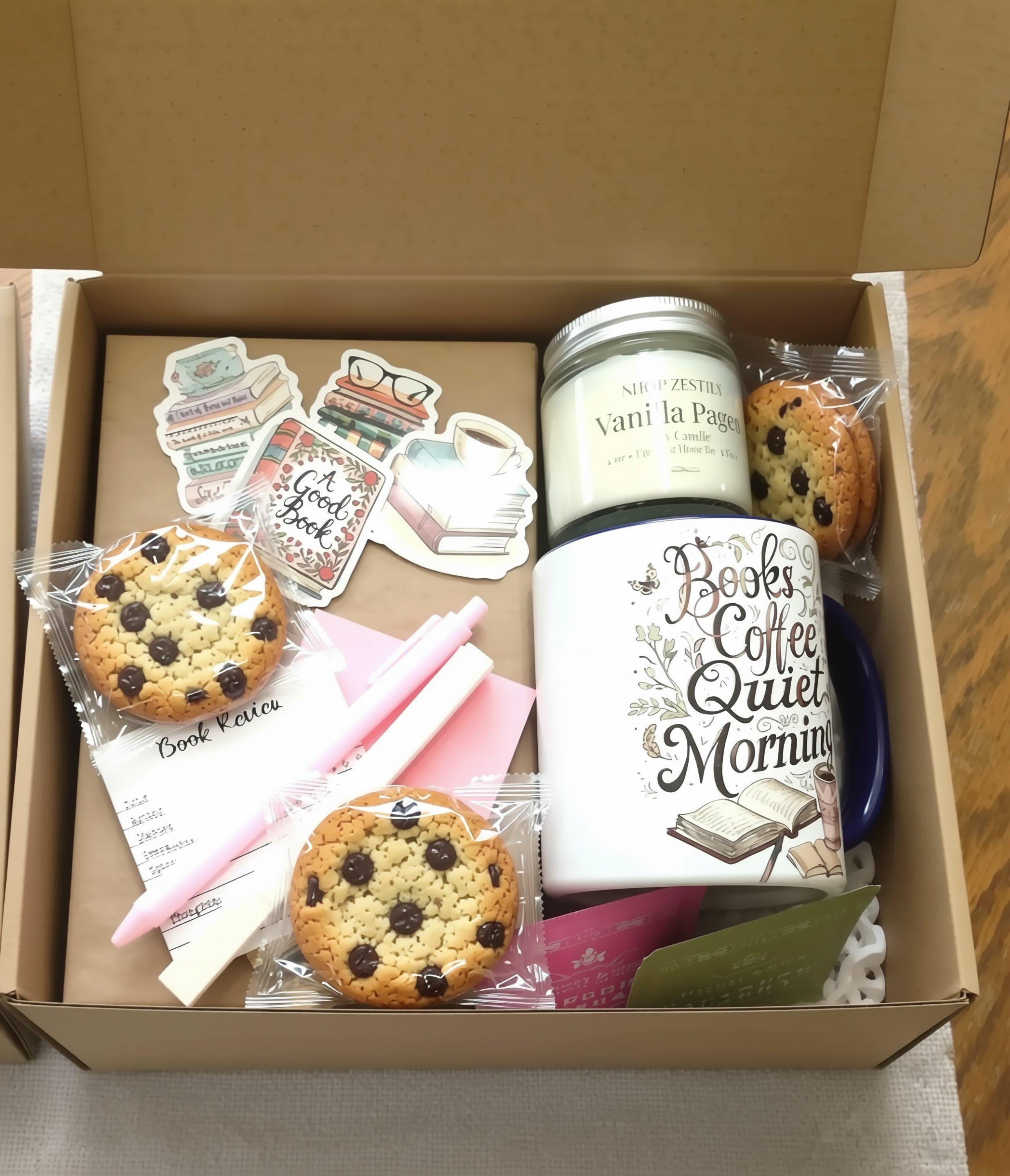 various items related to reading and writing, including a book, a pen, a candle, and a mug with a design featuring books and coffee.