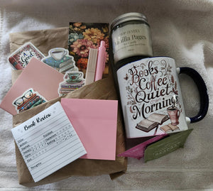 a variety of items, including a candle, a mug, a pink envelope, and some other miscellaneous objects, all placed on a white towel.