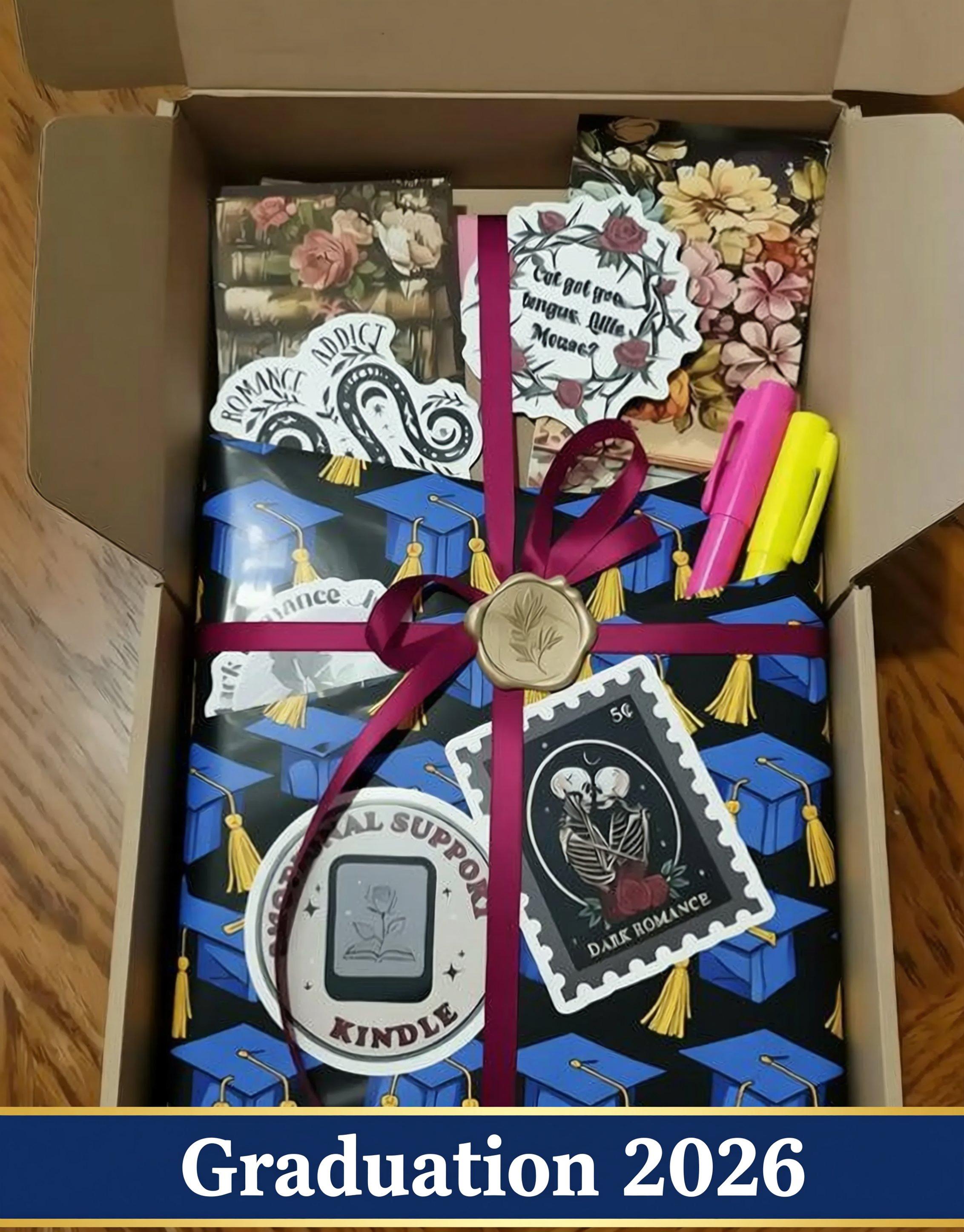 A pink box containing various items, including a book, a stamp, and some other decorative elements, all tied together with a purple ribbon.